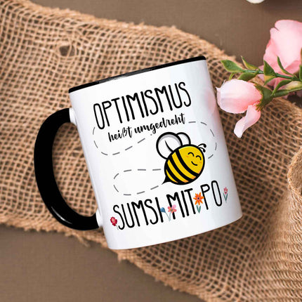 SEO. Bedruckte Tasse mit Spruch - Optimismus heißt umgedreht Sumsi mit Po - Schwarz & Weiß Linkreich