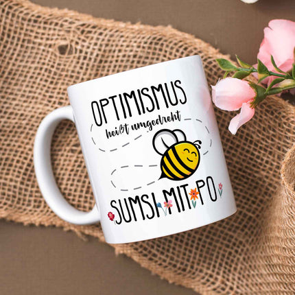 SEO. Bedruckte Tasse mit Spruch - Optimismus heißt umgedreht Sumsi mit Po - Weiß Linkreich