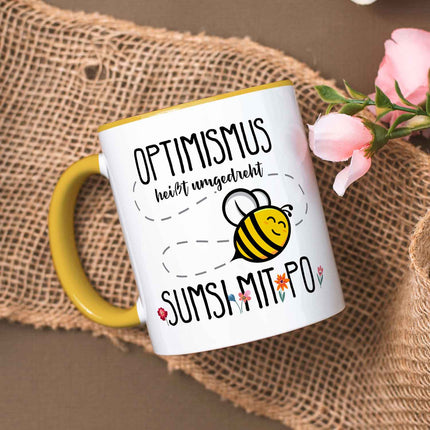SEO. Bedruckte Tasse mit Spruch - Optimismus heißt umgedreht Sumsi mit Po - Gelb Linkreich